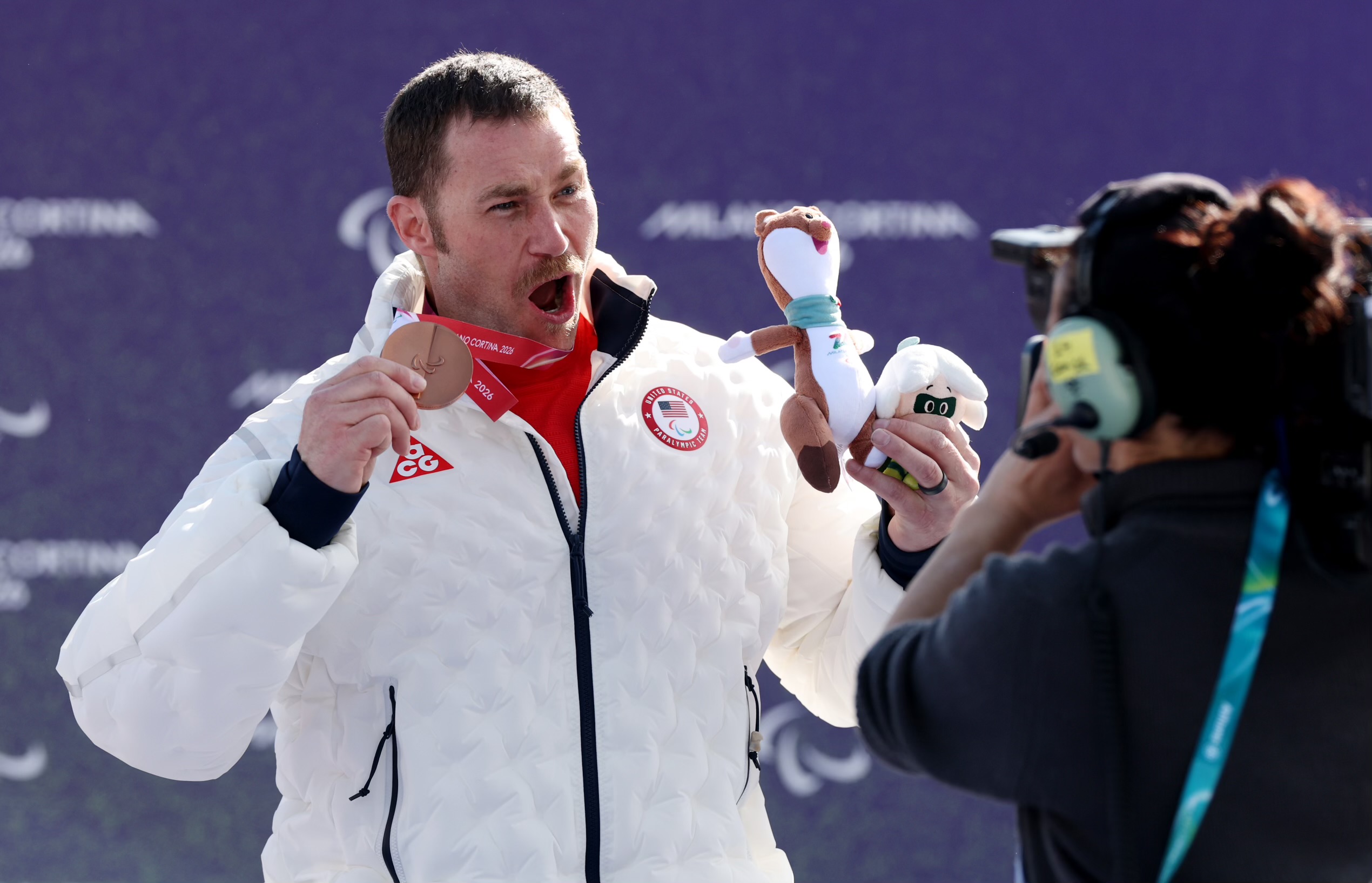 Mike Schultz celebrates with his medal on the podium at the 2026 Paralympic Winter Games 