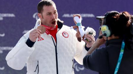 Mike Schultz celebrates with his medal on the podium at the 2026 Paralympic Winter Games 