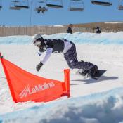 U.S. Para Snowboard athlete rounds a gate during a snowboardcross race